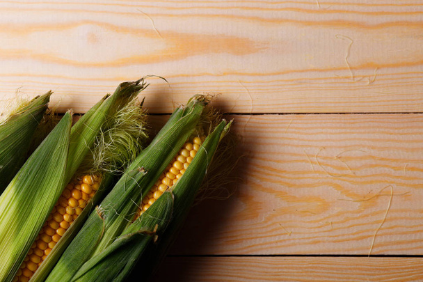 Cob of ripe yellow corn on wooden. Fresh, organic maize. Top view - Photo, Image