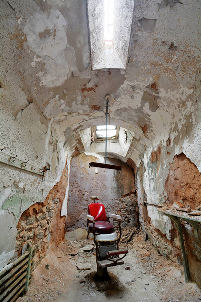 Silla de barbero roja dentro de una prisión abandonada
 - Foto, imagen