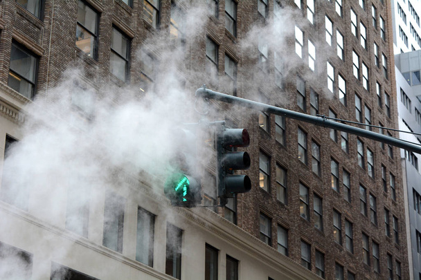 Green Arrow Traffic Signal Through Steam Venting from Street - Foto, Imagen