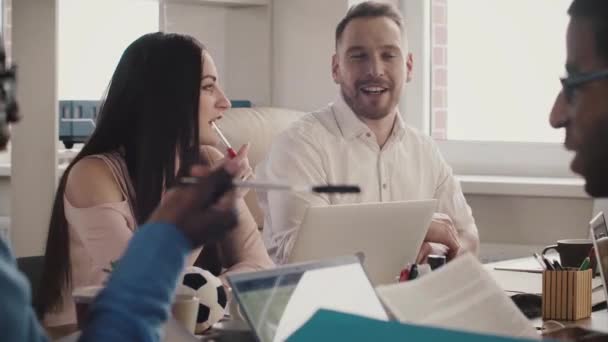 Empresários europeus felizes sorriem alegremente à mesa do escritório, discutindo o trabalho com parceiros multiétnicos câmera lenta
. - Filmagem, Vídeo