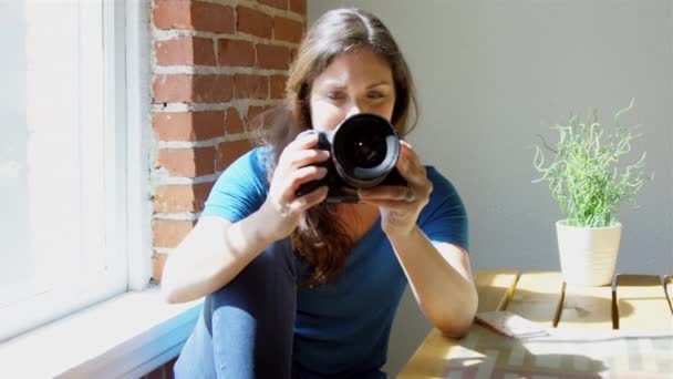 Cámara lenta de la mujer revisando fotos en su cámara y sonriendo
 - Metraje, vídeo