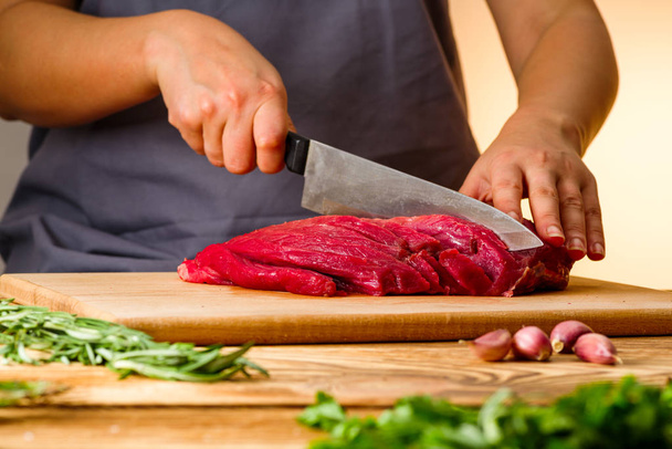 woman cuts fresh meat in the kitchen - Photo, Image