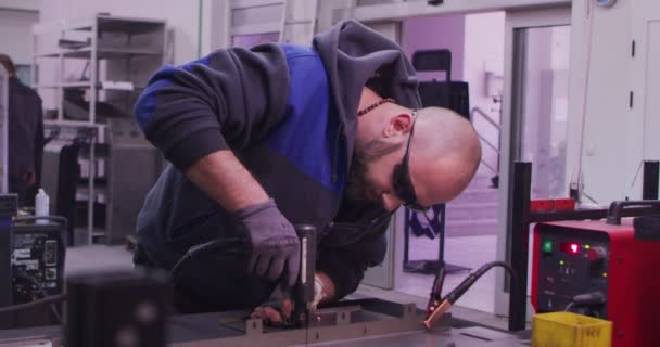 Ipari elektromos kerék munkavállaló köszörülés acél szerkezet és így szikrák gyár kis üzlet üzlet lassítva - Felvétel, videó