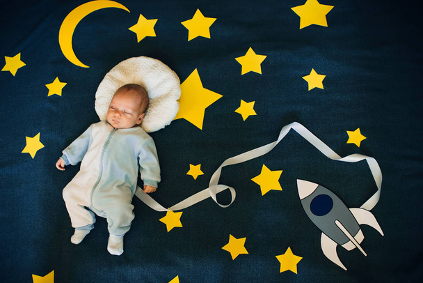 menino adormecido em um fundo do céu estrelado
 - Foto, Imagem