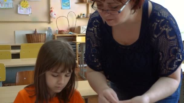 Bir öğretmen ve dört çocuk. öğretmen öğrencilere model hamuru öğretir - Video, Çekim