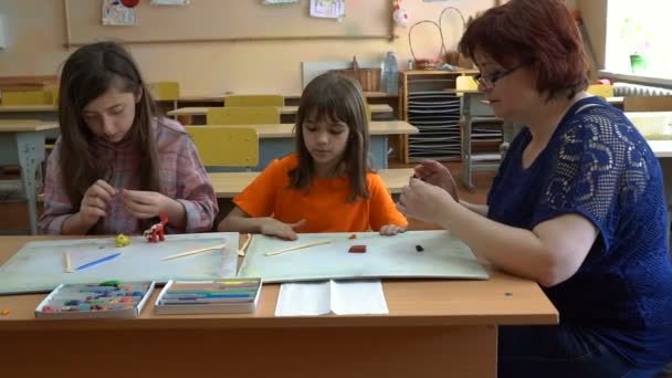 教師と 4 人の子供。先生が模型に学生を教える - 映像、動画