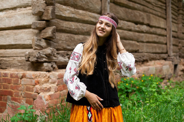Beautiful Ukrainian woman dressed in embroidered rustic exteriors - Фото, изображение