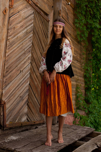 Mulher ucraniana bonita vestida em exteriores rústicos bordados
 - Foto, Imagem
