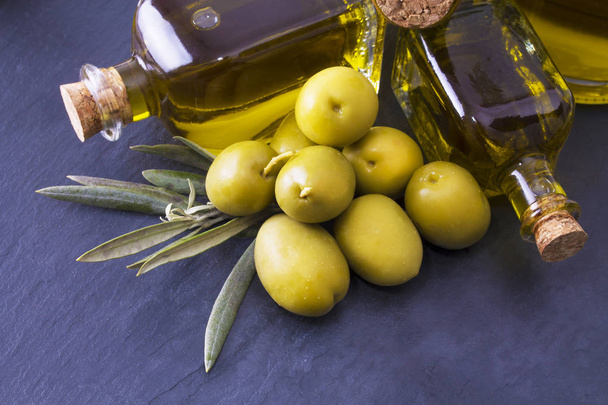 Olives and bottles of extra virgin olive oil - Photo, Image