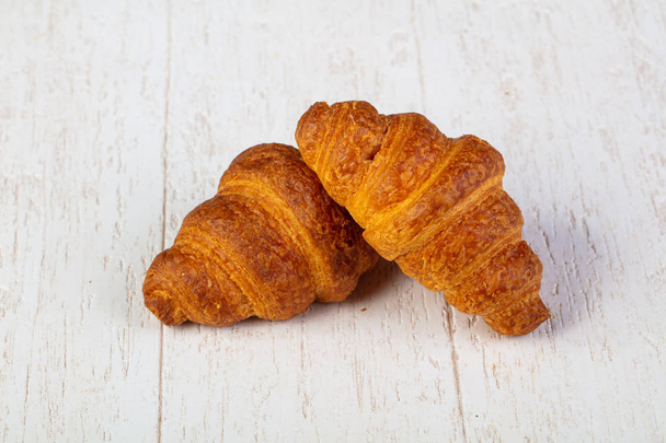 Sweet tasty croissant over wooden background - Photo, Image