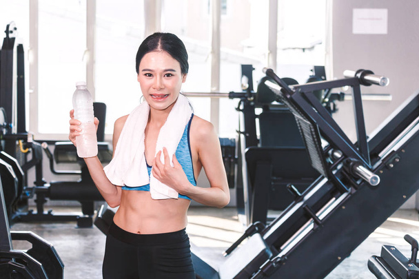 Butelka wody holdind sportowy kobieta z ręcznikiem na koncepcji gym.fitness i styl życia - Zdjęcie, obraz