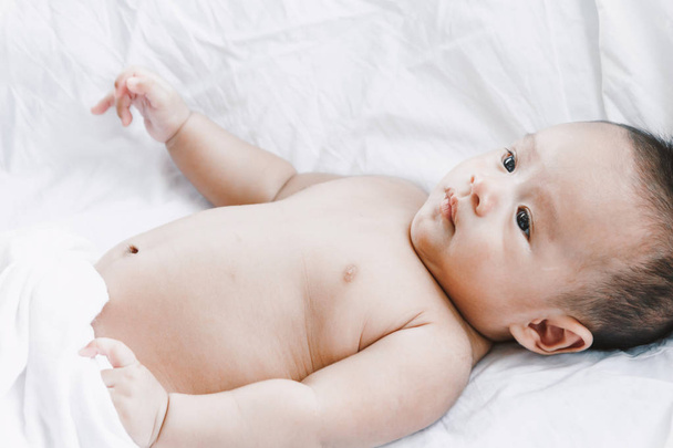 リラックス ルームで白いベッドの上の赤ちゃんの肖像画 - 写真・画像