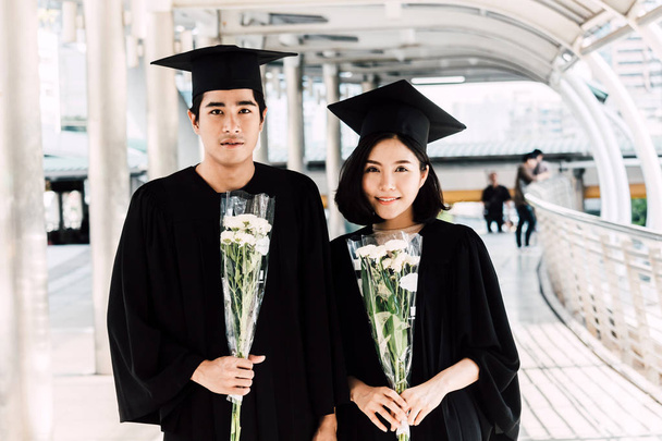 Deux étudiants heureux célébrant la réussite de l'obtention du diplôme sur fond de bâtiment du campus
 - Photo, image