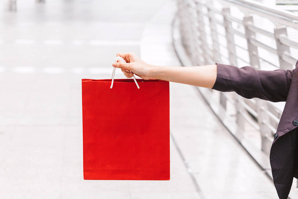 Mulher segurando saco de compras andando na rua
 - Foto, Imagem