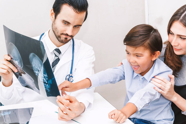 Arzt zeigt dem kleinen Jungen im Krankenhaus das Röntgenbild - Foto, Bild