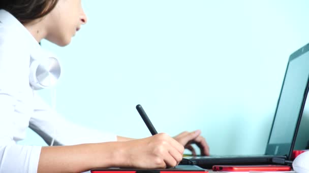 detail. Dívka na grafický tablet kreslit. Na volné noze. Ruka s pera, pohybující se na červený černý tablet. 4k, zpomalené. barvu pozadí. kopie prostor - Záběry, video