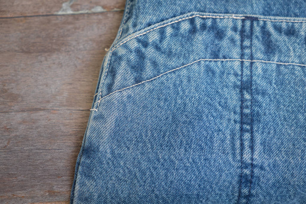 blue jeans on wood background texture close up - Valokuva, kuva