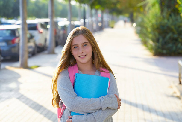 Blond kid student girl with notebook and backpack in the city back to school - Photo, image