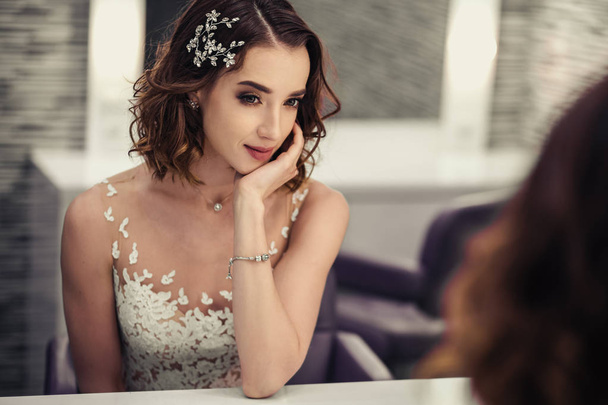 Portrait of young brunette bride woman in dressing room with wedding jewelry and dress - Photo, Image