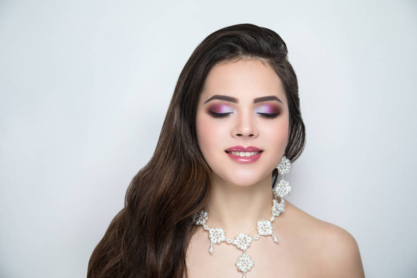 Close-up portrait of beautiful girl pretty lady with professional wedding makeup, brown arrows, long hair styling. Luxury new beige color make-up shiny lipstick glossy cosmetics. photo conceptual idea - Φωτογραφία, εικόνα