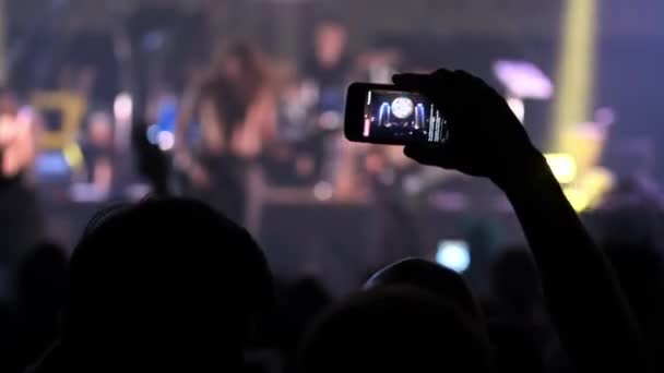 Άνθρωποι λήψη φωτογραφιών ή εγγραφή βίντεο με τα smart phones τους σε μουσική ροκ συναυλία σε ένα νυχτερινό κέντρο. heavy metal μπάντα εκτελεί.. - Πλάνα, βίντεο