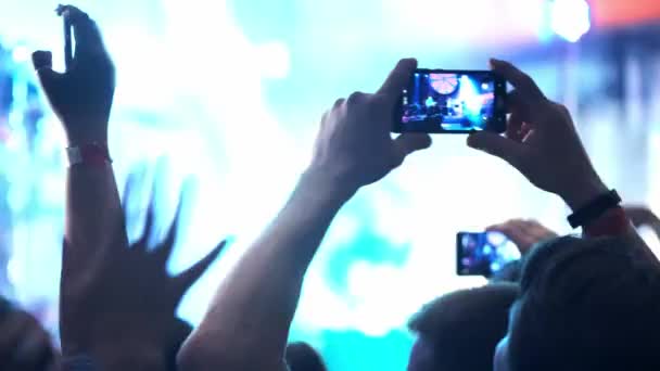 Lidé fotografování nebo nahrávání videa s jejich chytré telefony na hudební rockový koncert v nočním klubu. heavy metalová skupina provádí.. - Záběry, video