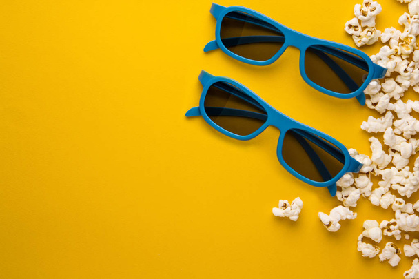 new 3d glasses and popcorn on a yellow background concept of cinema background - Fotoğraf, Görsel
