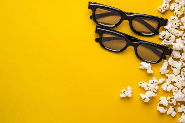 new 3d glasses and popcorn on a yellow background concept of cinema background - Foto, Bild