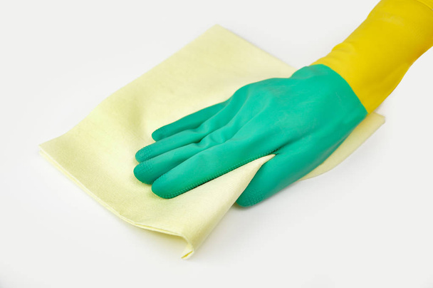Hand whit glove wiping surface with yellow rag isolated on white - Fotoğraf, Görsel