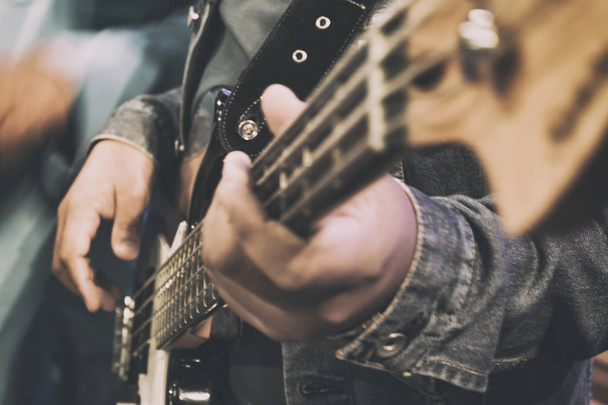 γκρο πλαν και επιλεκτική εστίαση εικόνας του χέρι παίζοντας ηλεκτρική επίδραση guitar.grain και θόρυβο shot - Φωτογραφία, εικόνα