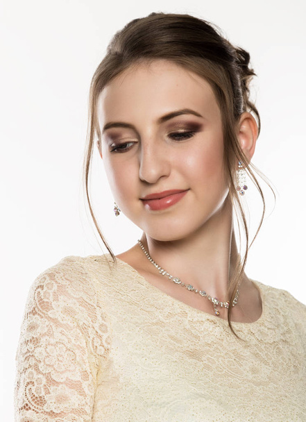 portrait of tender young woman in cream dress on a white background. professional make-up - Foto, afbeelding