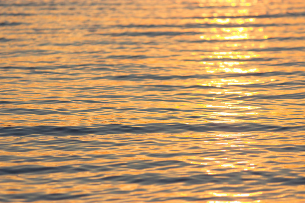 close-up texture of water, bronze waves at sunset - Photo, Image