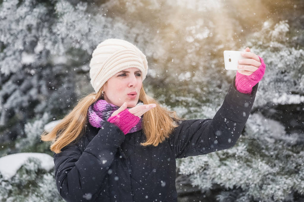 Happy woman taking selfie over winter background. - Foto, afbeelding