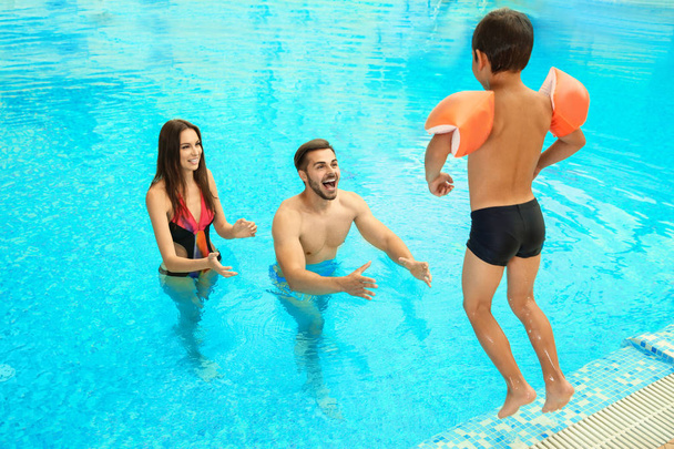 Happy family playing together in swimming pool - Foto, Imagen