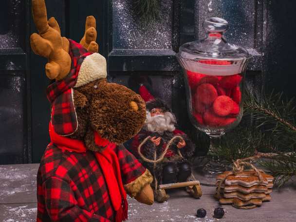 Διακοσμητικό χριστουγεννιάτικο φόντο, καλυμμένο με χιόνι παράθυρο, αναμνηστικά και νόστιμη γλυκύτητα. - Φωτογραφία, εικόνα