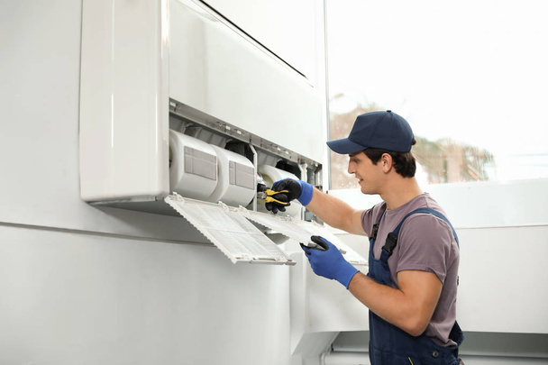 Male technician repairing air conditioner indoors - Photo, image
