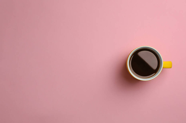 Keramische cup met warme aromatische koffie op kleur achtergrond, bovenaanzicht - Foto, afbeelding