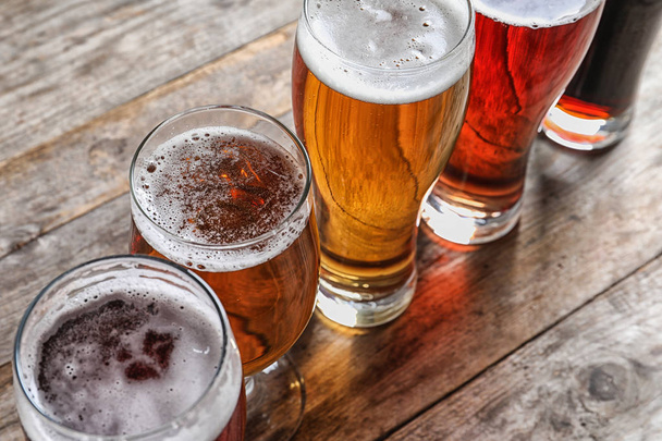 Glasses with different types of cold tasty beer on wooden table - Photo, Image