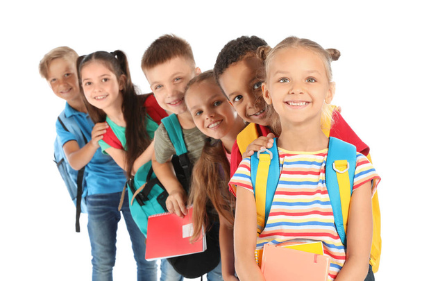 Group of little children with backpacks and school supplies on white background - Foto, imagen