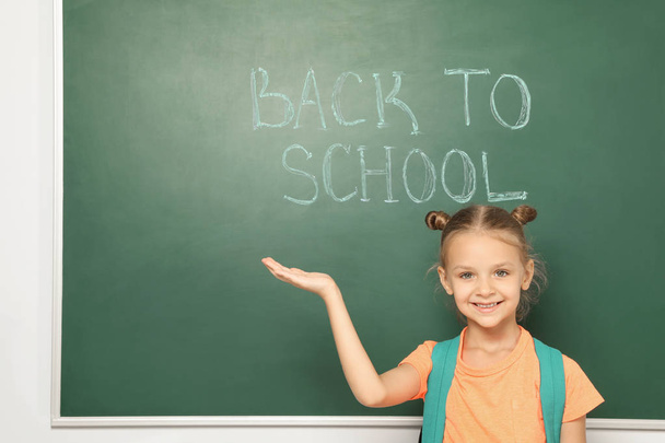 Little child near chalkboard with text BACK TO SCHOOL - Fotoğraf, Görsel
