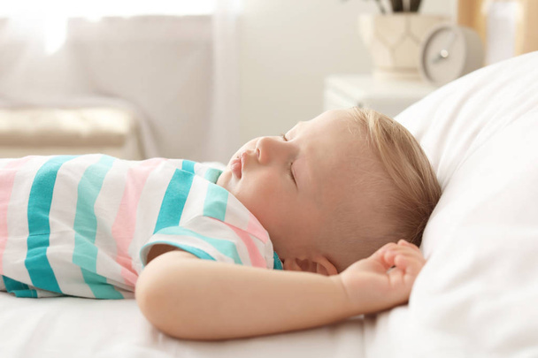 Little child sleeping on bed at home - Foto, afbeelding