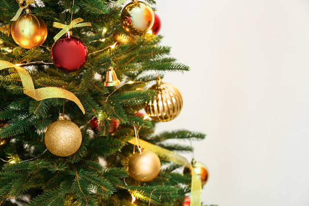 Beautiful Christmas tree with fairy lights and festive decor on color background - Fotoğraf, Görsel
