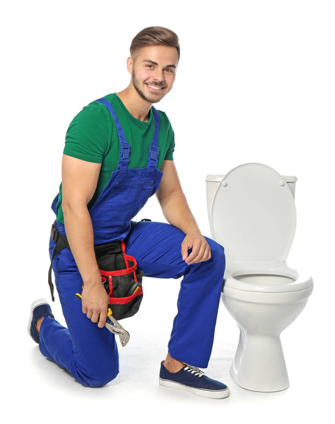 Young man working with toilet bowl, isolated on white - Foto, afbeelding