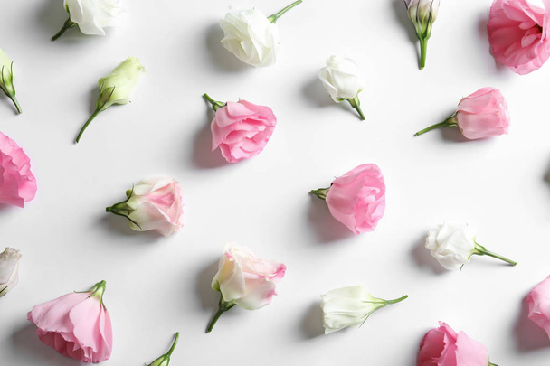 Flat lay composition with beautiful Eustoma flowers on light background - 写真・画像