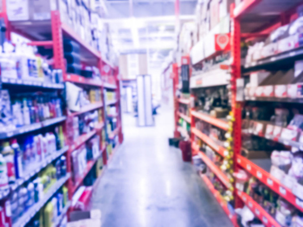 Defocused home improvement retailer store with racks of lubricant, automotive, towing, garage organization. Blurred image background of large hardware store in America - Photo, Image