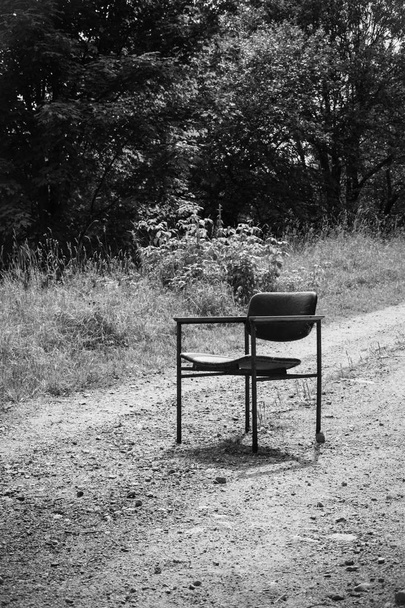 παλιά καρέκλα σε ένα χωματόδρομο σε μαύρο και άσπρο - Φωτογραφία, εικόνα