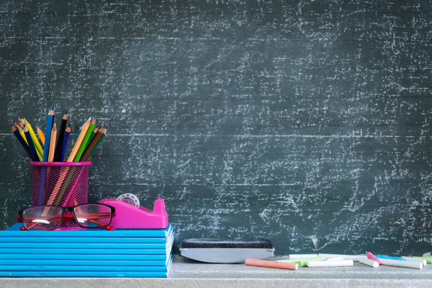 Education or back to school Concept. glasses, pencils, note books, chalk, eraser over chalkboard background. - Foto, Imagen