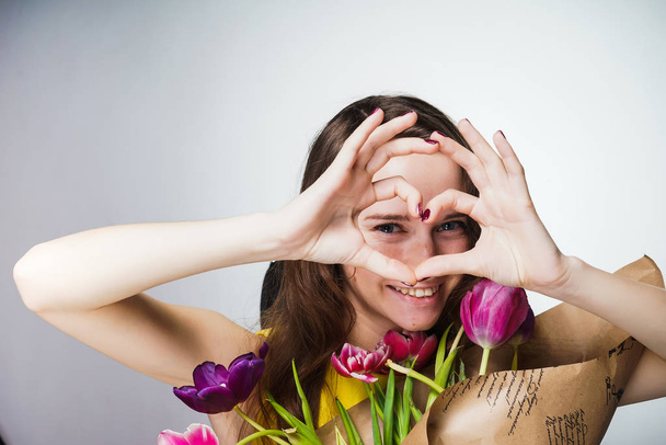 charming beautiful girl holding bouquet of flowers, good mood, smiling - Фото, изображение