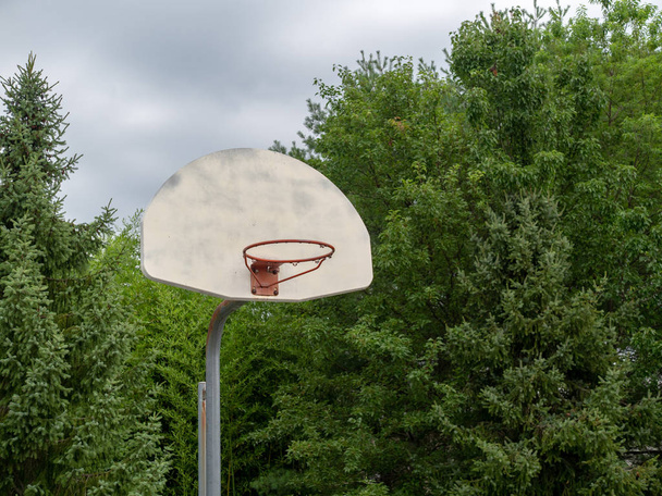 Overzicht stalen basketbal hoepel ontbreekt van haar net op bewolkte dag - Foto, afbeelding