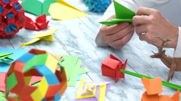 Het maken van groene origami papier kraan close-up. - Video